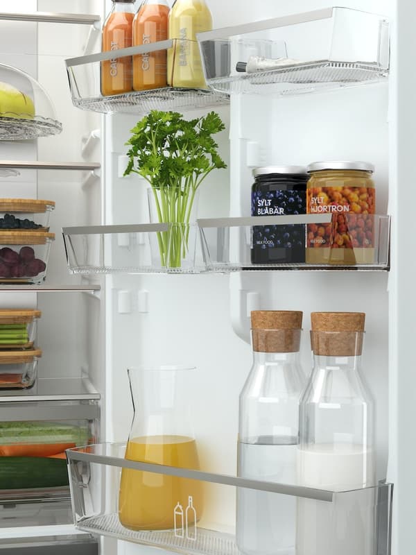 Kühlschrank mit Glasflaschen, frischen Kräutern und sauber sortierten Vorräten – nachhaltige Aufbewahrungsideen für die Küche