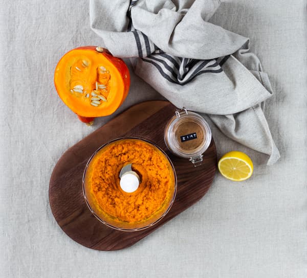 Kürbis und Karotten werden in einem Mixer für selbstgemachten Kürbis-Karotten-Aufstrich zerkleinert.