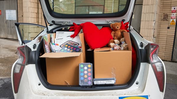 Kufor auta plný hračiek a potrieb na kreslenie pre deti.