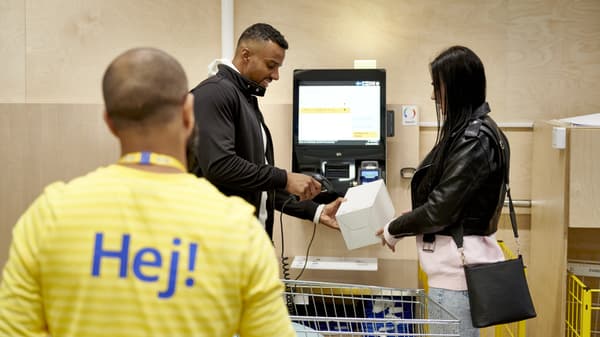 Kunden die an der Kasse von einem Mitarbeiter betreut werden.