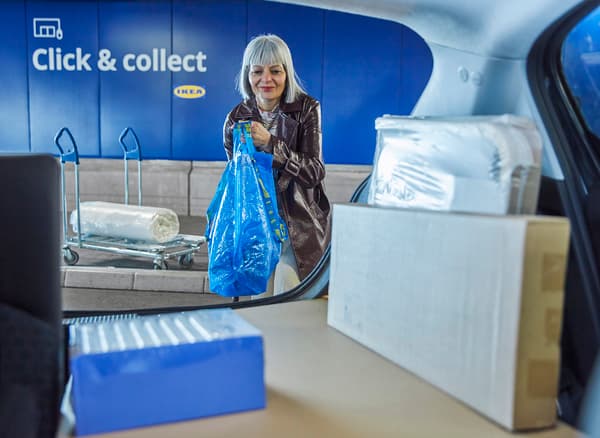 Kundin läd ihre Einkäufe am Click & collect in den Kofferraum.