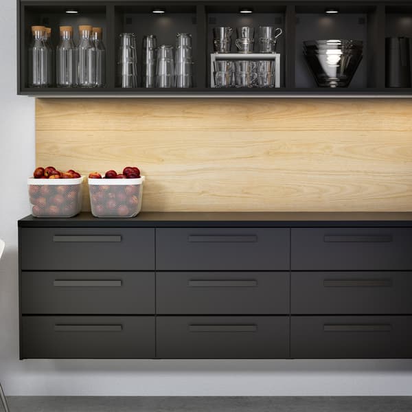 KUNGSBACKA kitchen in anthracite with nine drawers and open upper cabinets with water carafes and glasses.