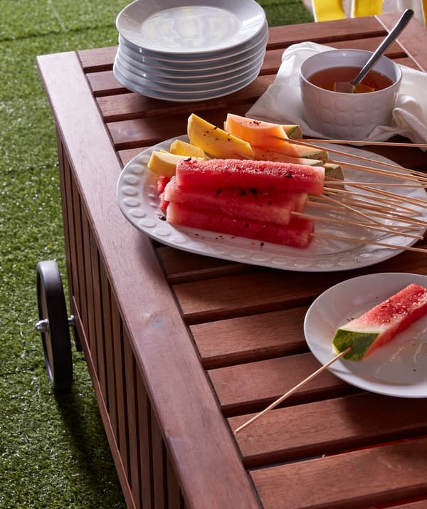 Kúsky melóna a manga na bambusovej špajli IKEA GRILLTIDER na veľkom bielom tanieri.