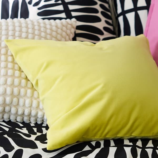 Kuvassa on kauden väreissä loistavia tyynyjä: keltainen, vaaleanpunainen ja mustavalkoinen.