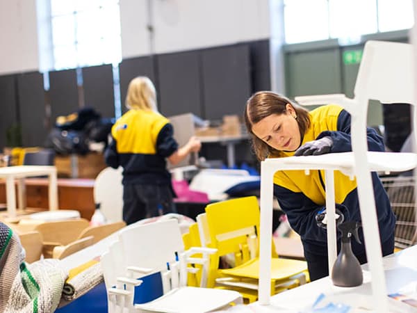 Kvinnlig IKEA medarbetare rengör begagnad stol