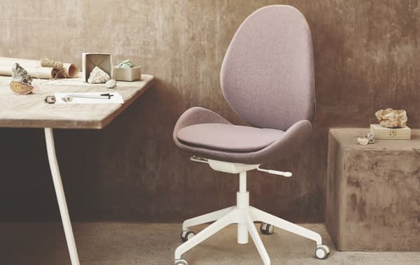 La chaise de bureau HATTEFJÄLL rose et blanche installée dans un bureau.