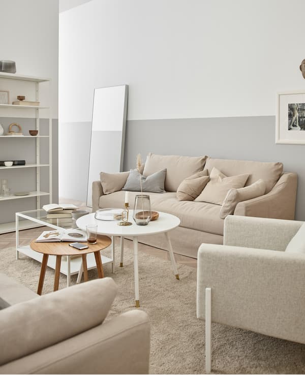 La fusta, el blanc-crema i el vidre creen una sala elegant i orgànica.