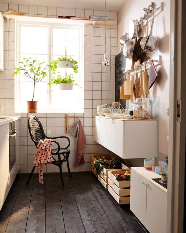 La même petite cuisine équipée pour convenir à un parent et à un enfant en bas âge. Avec plein de rangements, des ustensiles de cuisine accrochés à des barres et une dînette.