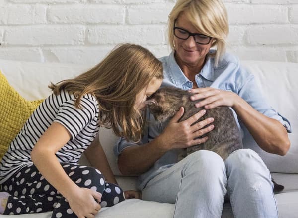 La Mercedes (a la dreta) i l'Emília fan carícies al gat de la família.