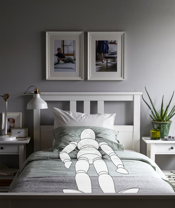 La sagoma di un manichino coricato in posizione dritta e simmetrica in una camera da letto molto ordinata - IKEA