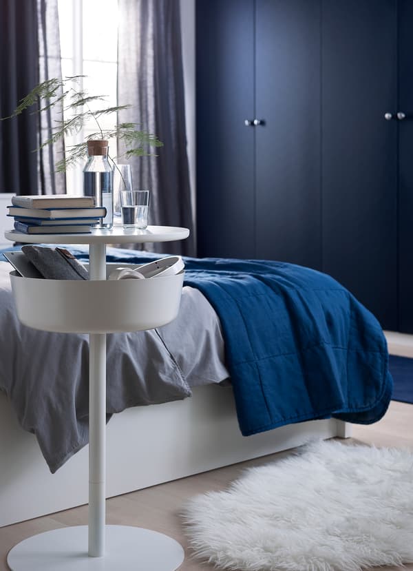 La table de chevet IKEA LIERSKOGEN blanche possède un récipient arrondi qui peut recevoir chargeurs, câbles et téléphones, livres, bijoux et autres petits accessoires.