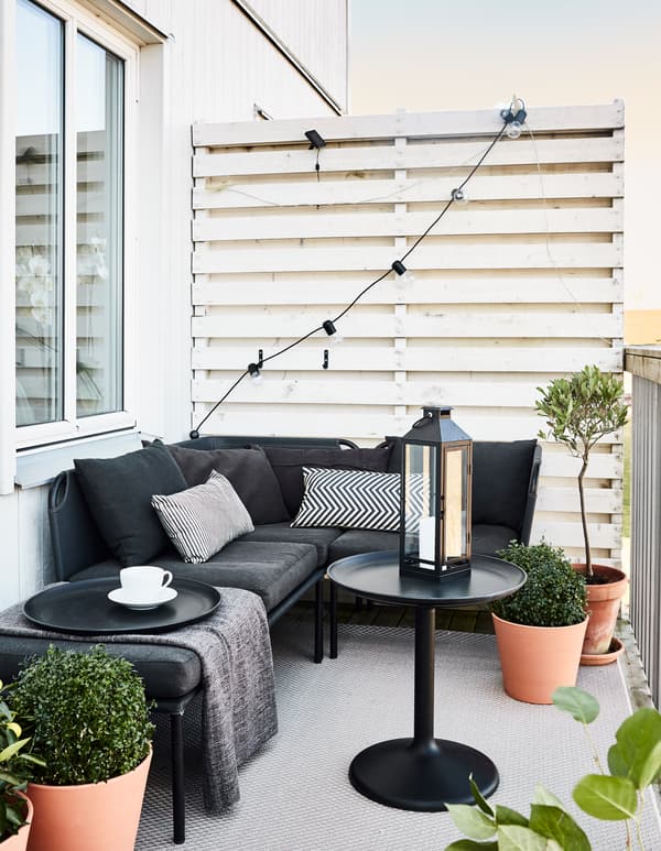 L’ameublement de la terrasse a été choisi dans des tons neutres, bien entendu, et comprend un canapé, une table basse et un tapis.