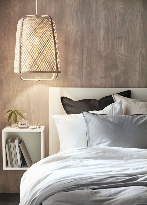 Lampa wisząca IKEA KNIXHULT, bambusowa, dająca delikatne światło obok łóżka.