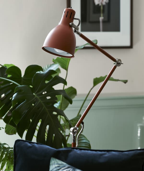 Lampada da terra color mogano in una stanza con delle piante.