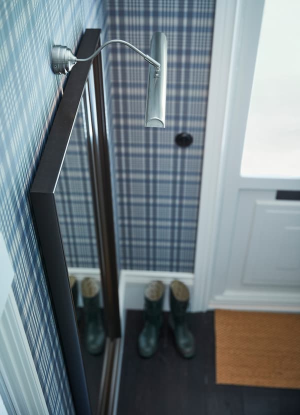 Lampadarul iluminat ÅRSTID cu LED de la IKEA este nichelat și are un abajur reglabil, pentru a nu se reflecta în oglinzi sau în lucrările de artă.  