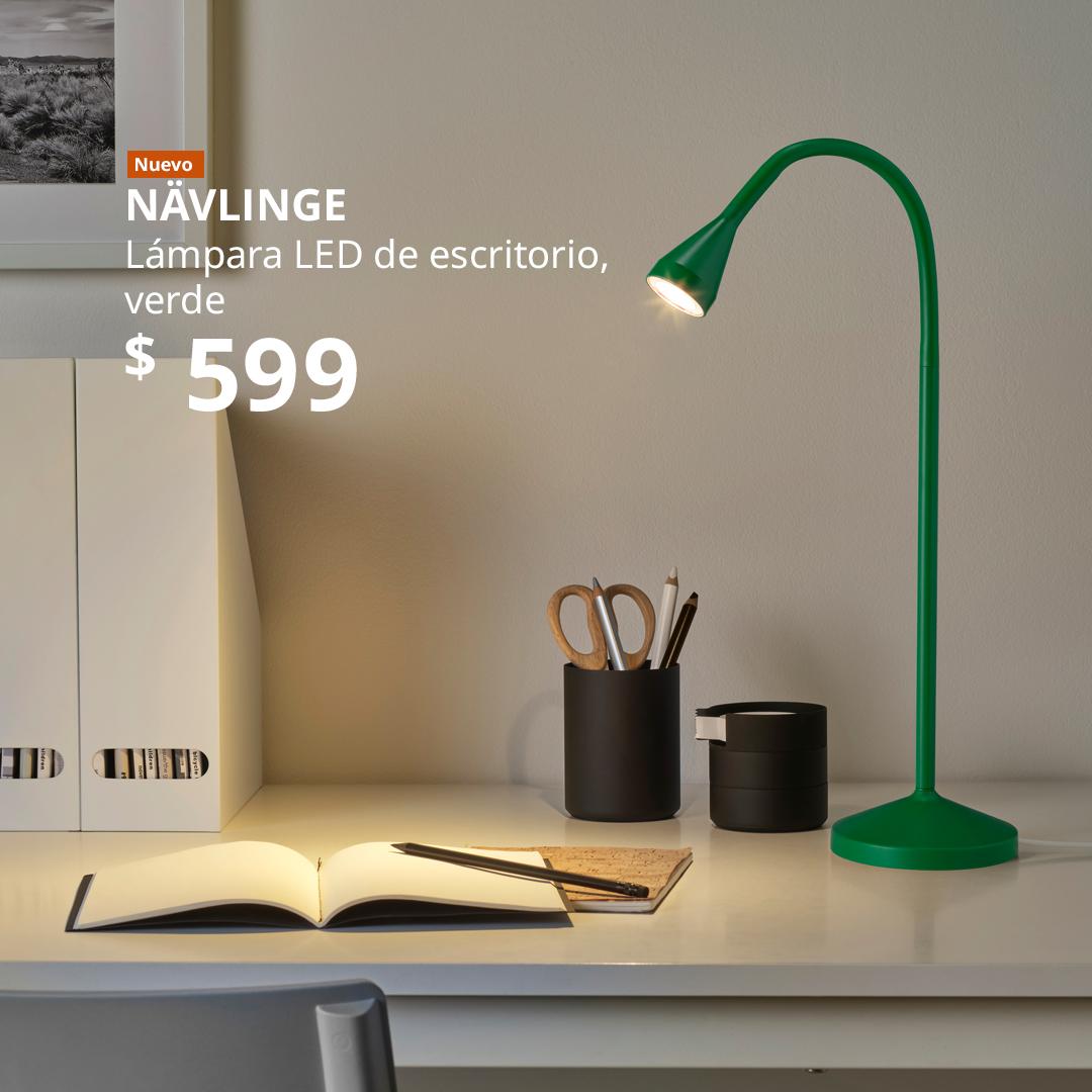 Lámpara LED de escritorio NÄVLINGE verde sobre un escritorio blanco.