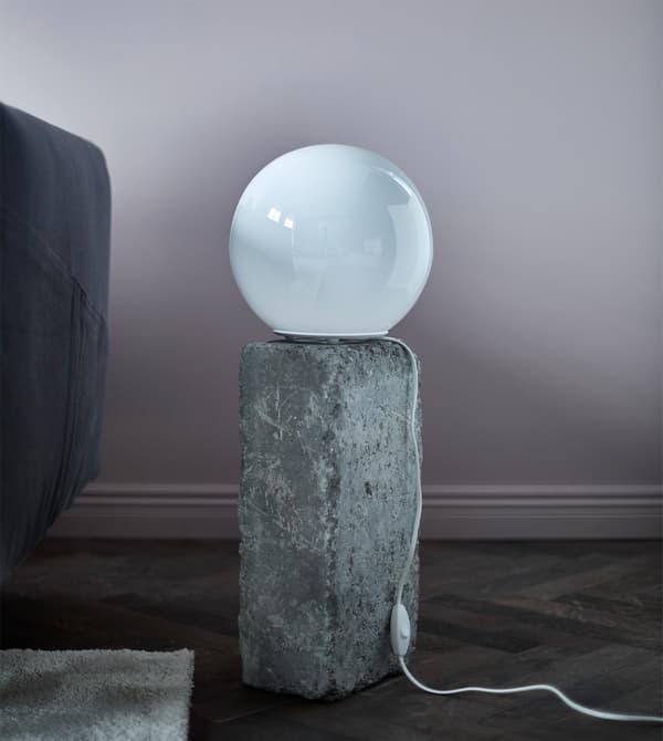 Lampe de table ronde posée sur une pierre.