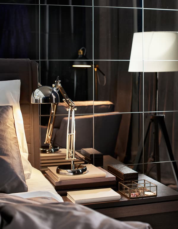 Lampe de travail de style industriel utilisée comme lampe de chevet, avec lampadaires en arrière-plan.
