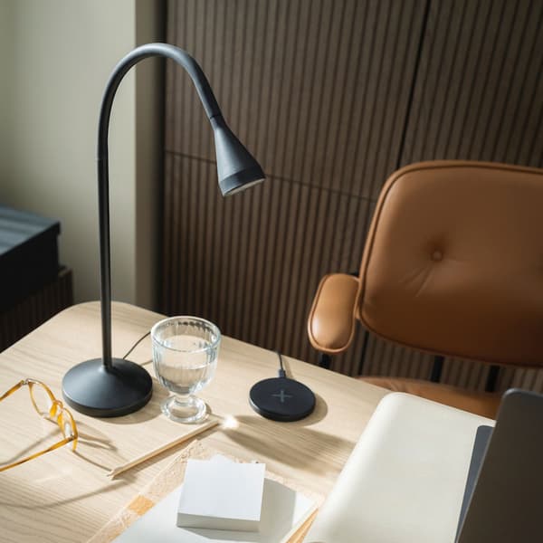Lampe NAVLINGE noire, posée sur un bureau en bois 