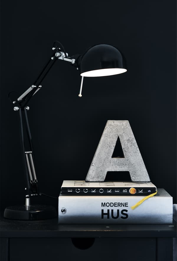 Lampe noire et pile de livres.