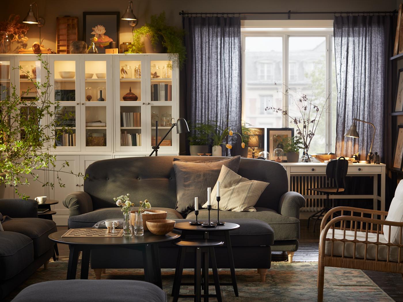 Landelijke woonkamer met veel ingelijste prenten en boeken uitgerust met een ESSEBODA zitbank en HAVSTA opbergcombinaties.