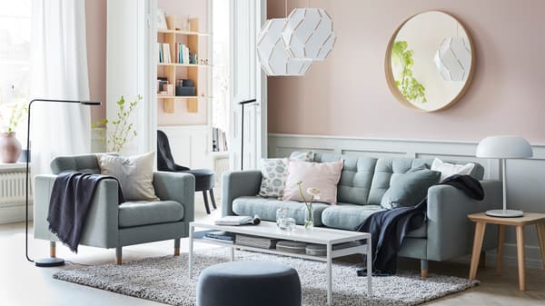 LANDSKRONA light green sofa, SJÖPENNA pendant lamps and black YPPERLIG standing lamps in a pink walled living room.