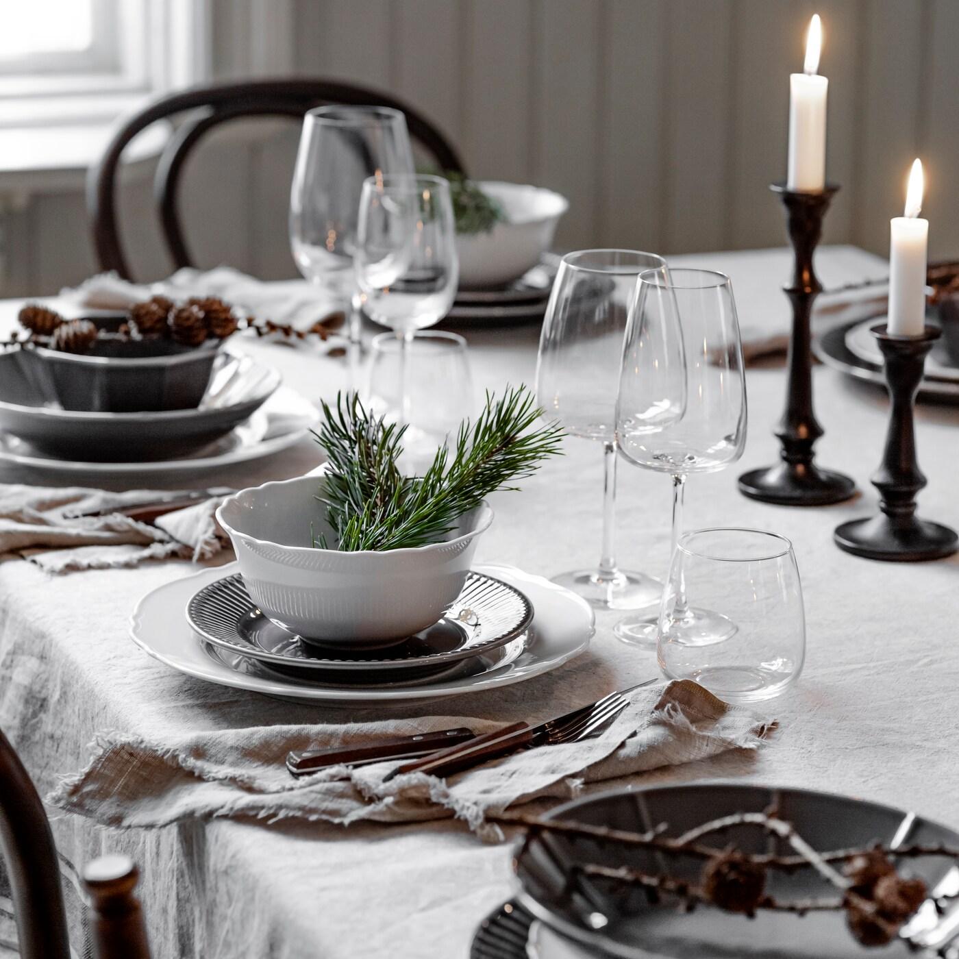 Lantligt dukat julbord med vita och gråa tallrikar.