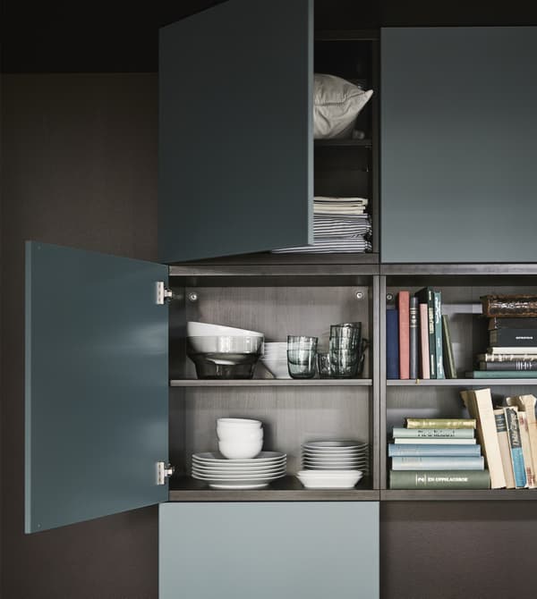 Las puertas VALVIKEN en gris turquesa con un marco BESTÅ negro-marrón crean espacio de almacenamiento en este salón moderno.