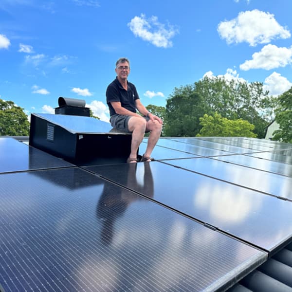 Lasse sitter på sitt tak där han nyligen installerat solpaneler.