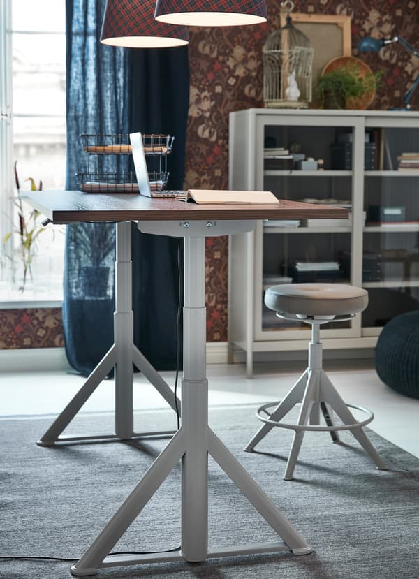 Le bureau assis/debout IKEA IDÅSEN blanc à tablette en bois lisse se règle à la hauteur qui convient à chaque membre de la famille.