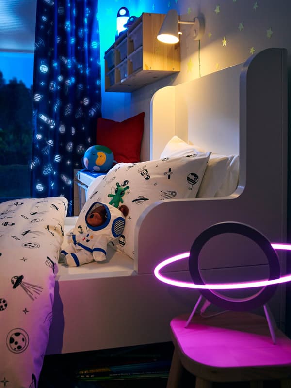 LED lampička AFTONSPARV před postelí s povlečením AFTONSPARV. 