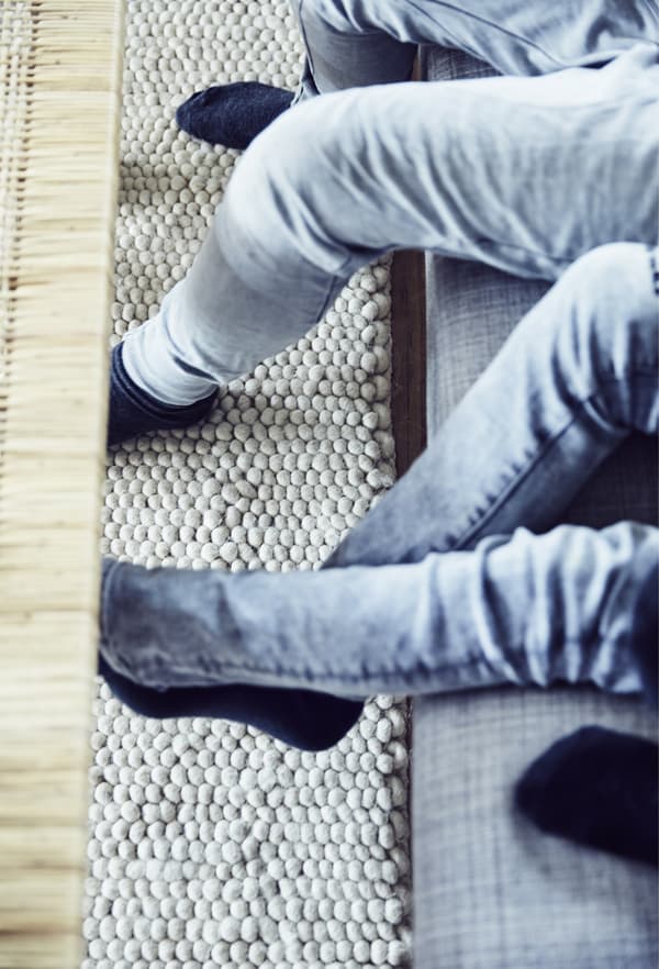 Legs dangling over the edge of a sofa, plus coffee table.