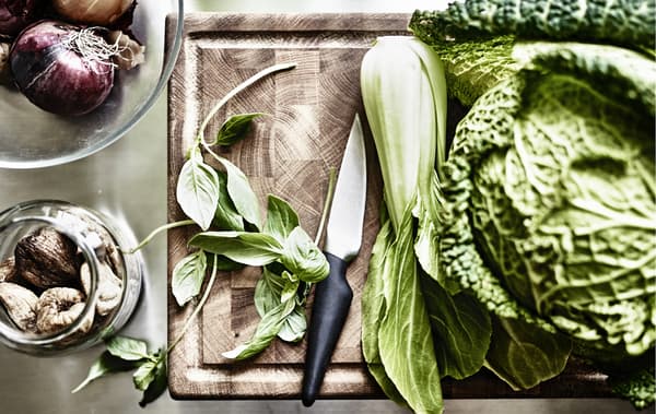 Légumes verts et à feuilles sur une planche à découper en bois.