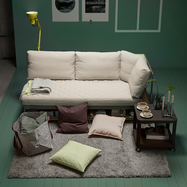Les housses de coussin gris-vert IKEA SANELA en velours de coton apportent de la douceur au séjour. La desserte noire TINGBY en panneau de fibres est dotée de roulettes et d’une tablette qui peut servir de rangement.