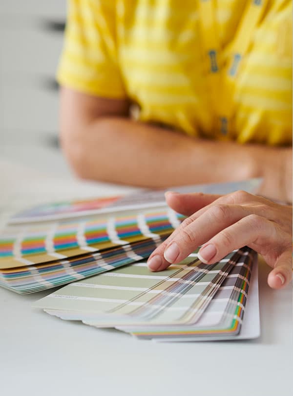Les mains d'une designer d'intérieur qui tiennent des échantillons de couleurs de peinture.