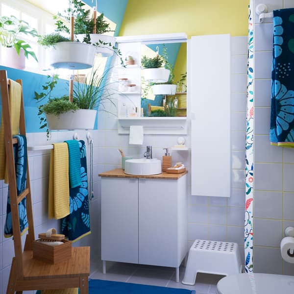 Les meubles IKEA LILLÅNGEN sont parfaitement adaptés aux petites salles de bain et parfaits dans les logements de location où il est interdit de percer des trous dans les murs. Relooke ta salle de bain avec des plantes et les serviettes de bain SANDVILAN aux motifs floraux bleu vif et vert foncé.