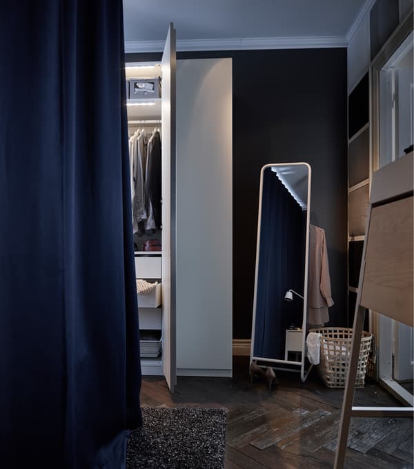 Les murs bleu foncé de cette chambre et les draps blancs du lit contribuent au calme de la pièce. Les rideaux capitonnés bleu foncé suspendus à l’extérieur du lit font obstacle au bruit et à la lumière. Un tapis brun foncé sur le plancher en bois apporte une touche de douceur et de chaleur.