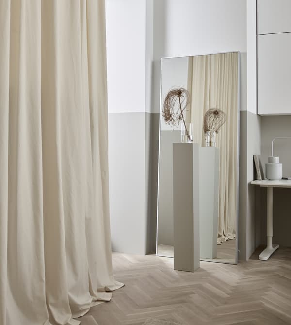 Les rideaux ne servent pas juste aux fenêtres. Accrochez-en un le long d’un mur, pour adoucir le look de la pièce.