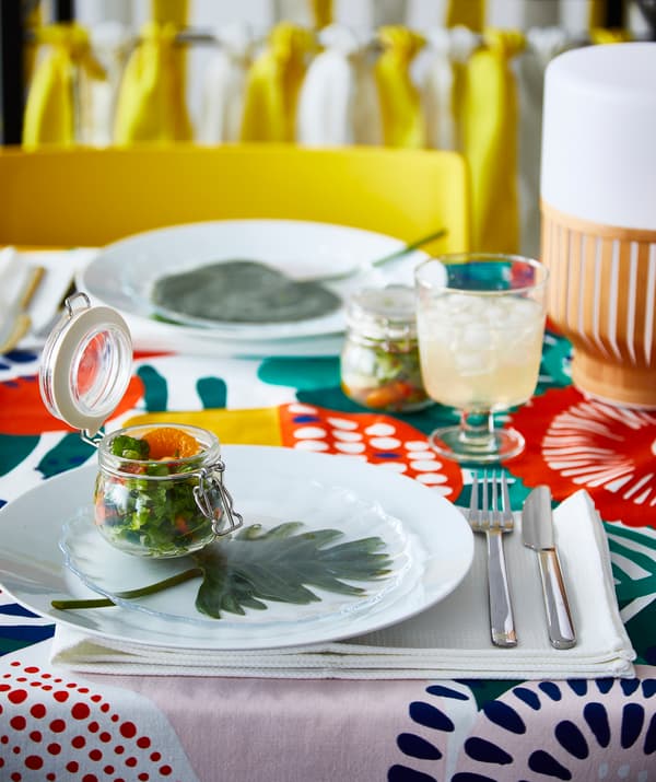 Letný šalát naservírovaný v priehľadnej dóze IKEA KORKEN na farebne prestretom stole.