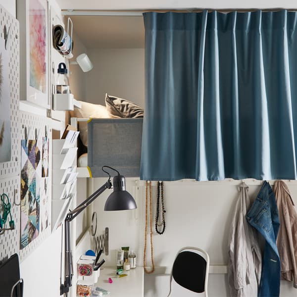 Letto a soppalco bianco con tenda azzurra fissata a un binario sul soffitto – IKEA