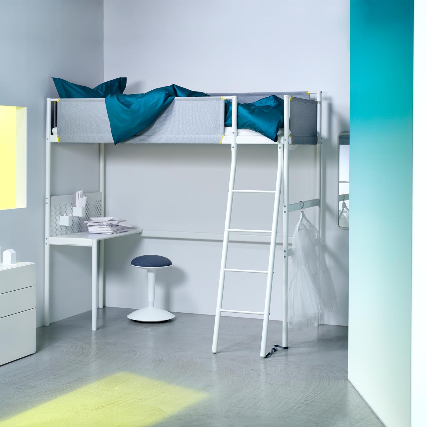 Letto a soppalco VITVAL bianco con sponde in tessuto, scala e scrivania in una camera da letto con pareti bianche e con un sgabello NILSERIK sotto la scrivania. - IKEA