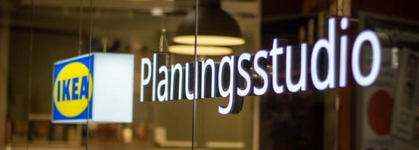 Leuchtendes Schild mit der Aufschrift „Planungsstudio“ und IKEA-Logo an einer Glaswand