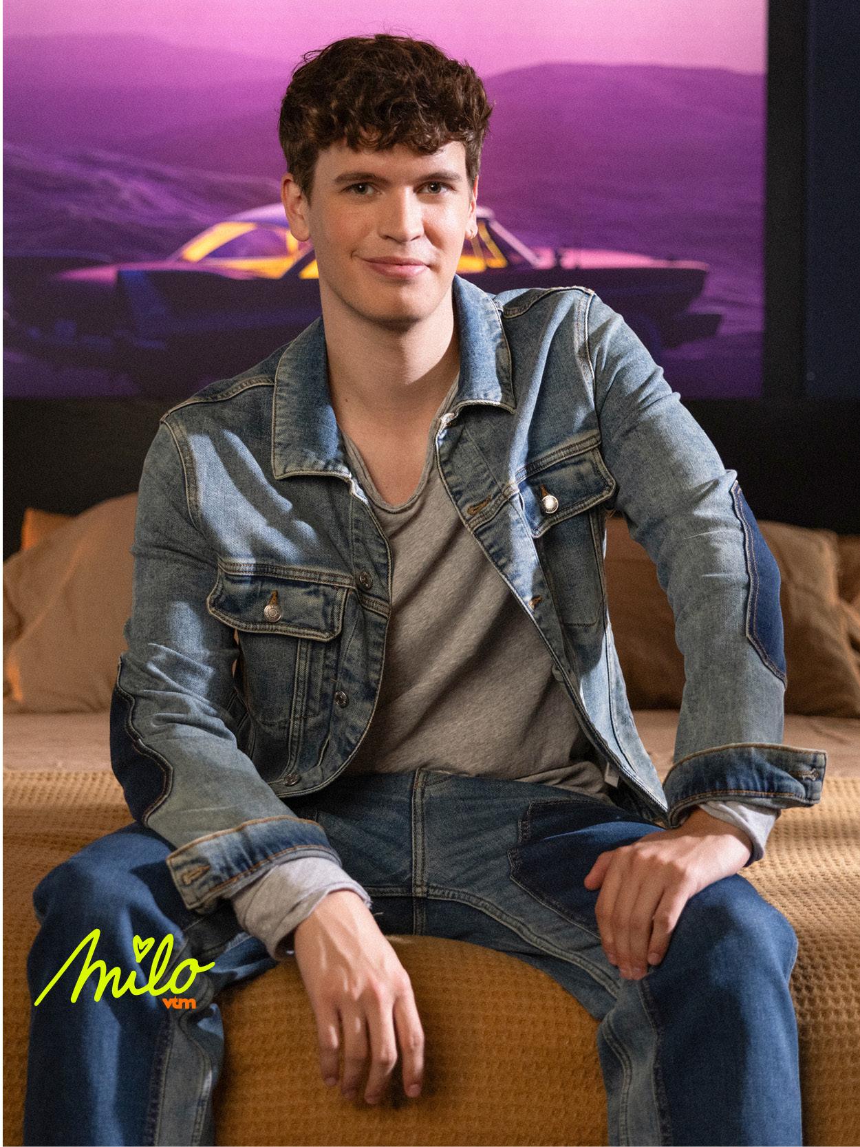 Liam en tenue en denim crée une ambiance décontractée et moderne avec un fond violet.