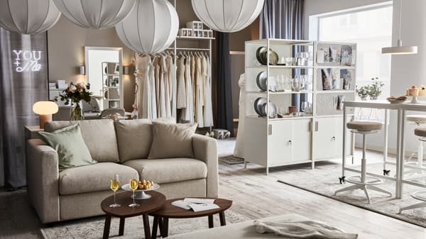 Lichte, luchtig ingerichte ruimte met VIMLE zitbank, twee TROTTEN kasten, verschillende REGNSKUR hanglampen en decoratie.