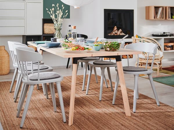 Light grey chairs were placed around a light wooden table.