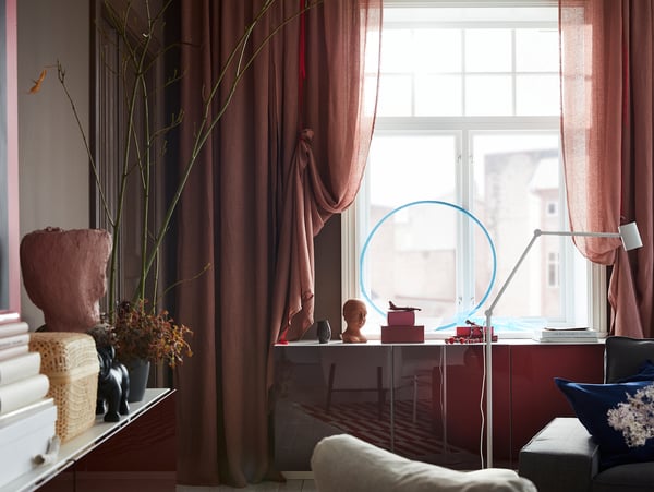 Light pink-brown LEJONGAP curtains are draped with red ribbons and hung in front of a window.