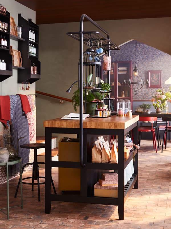 L’îlot de cuisine VADHOLMA et le tabouret de bar KULLABERG utilisés comme espace d’accueil, avec un présentoir pour les produits à vendre.
