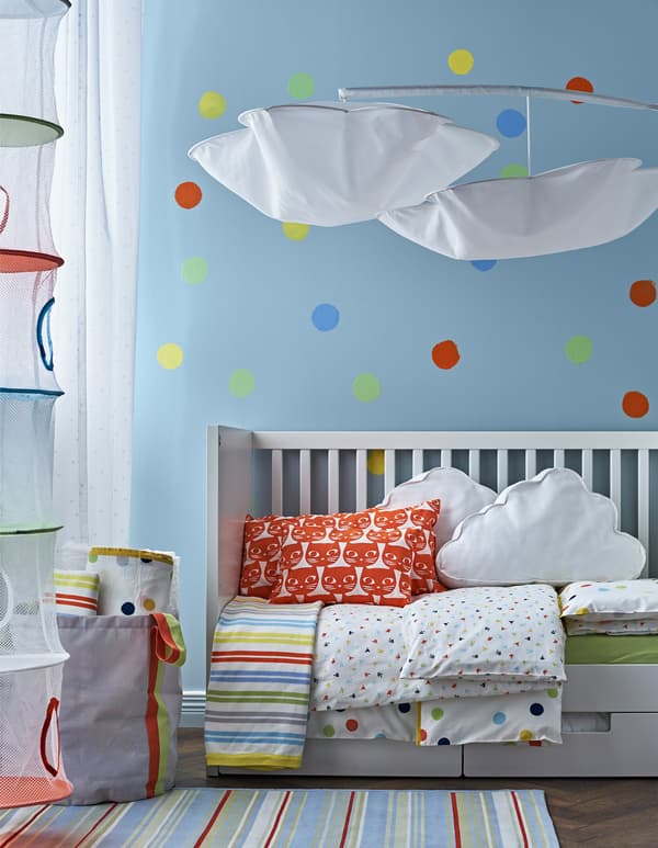 Linge de lit, tapis, et pastilles peintes au mur, le tout en couleurs vives, passeront facilement la transition de chambre de bébé à chambre d’enfant.