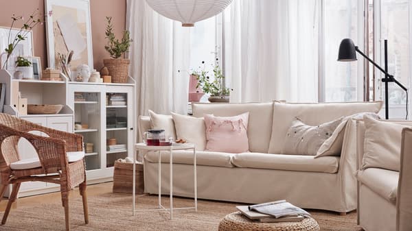 Link to 'A room where work and life is in balance' - image of a living room with a beige sofa and accessories in natural textures.