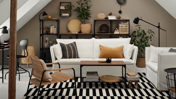 Link to 'A stylish living room with a calm atmosphere' - image of a living room with white sofas and a boldly striped black and white rug.